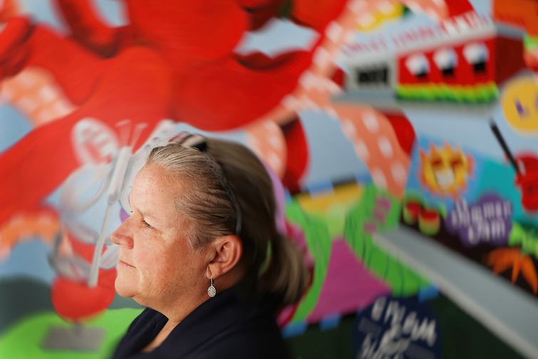 Sheryl Lazenby is a graphic artist, photographer, muralist, illustrator and chalk artist who is working to preserve a portion of a removed Aminah Robinson mural.